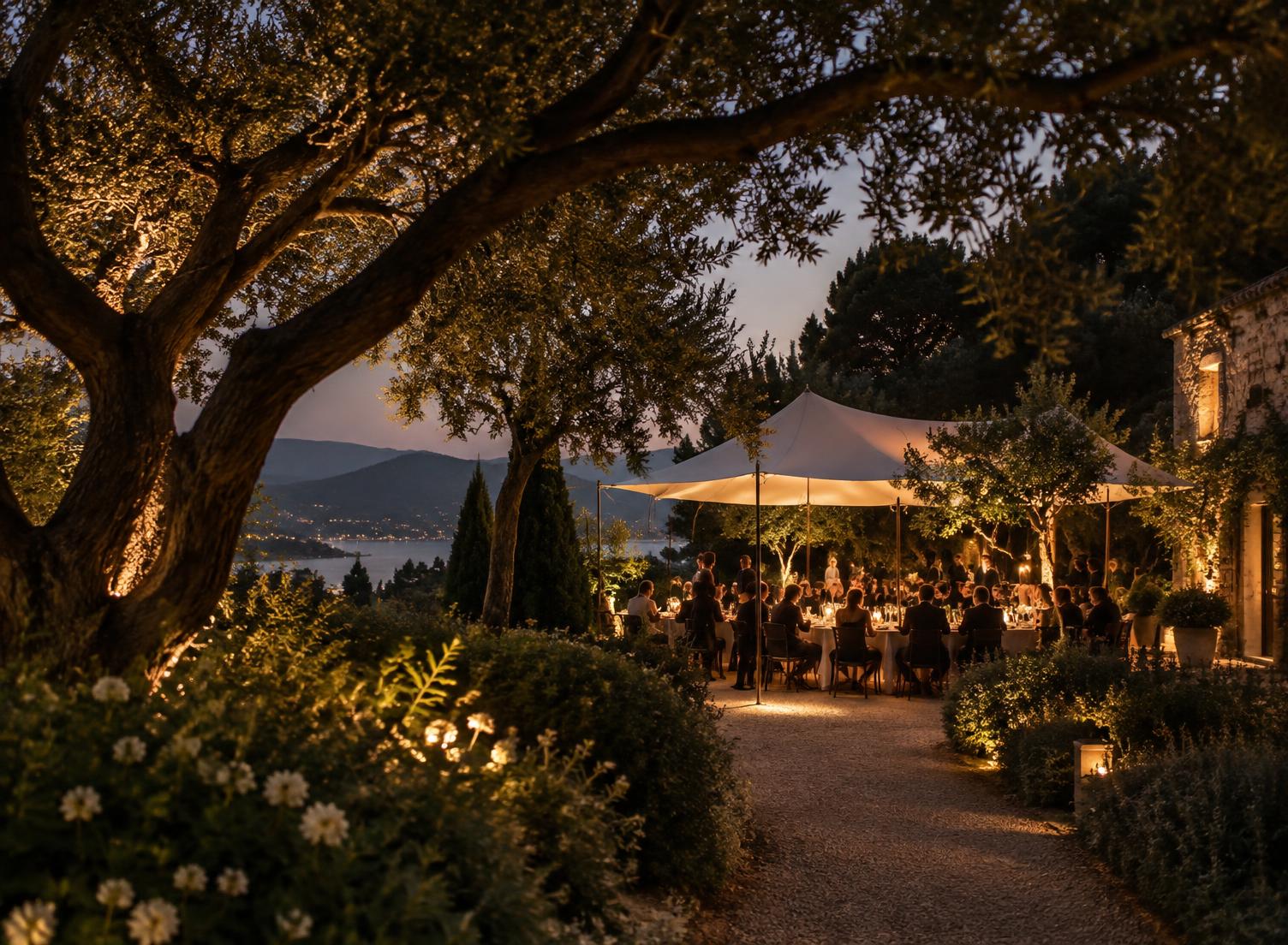 Guests gathered beneath trees beside the water